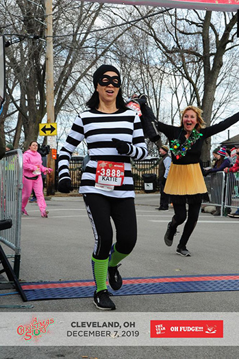 Katie Ho crossing finish line of A Christmas Story 5K Run