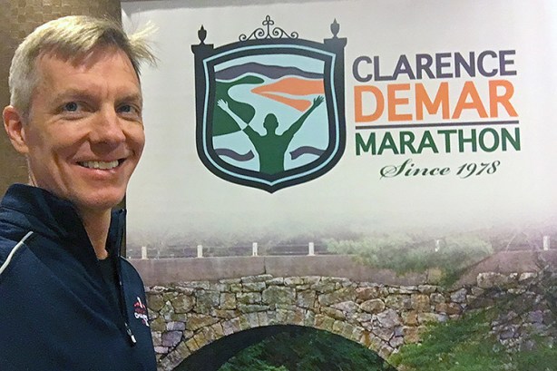 Mike Sohaskey with Clarence DeMar Marathon sign